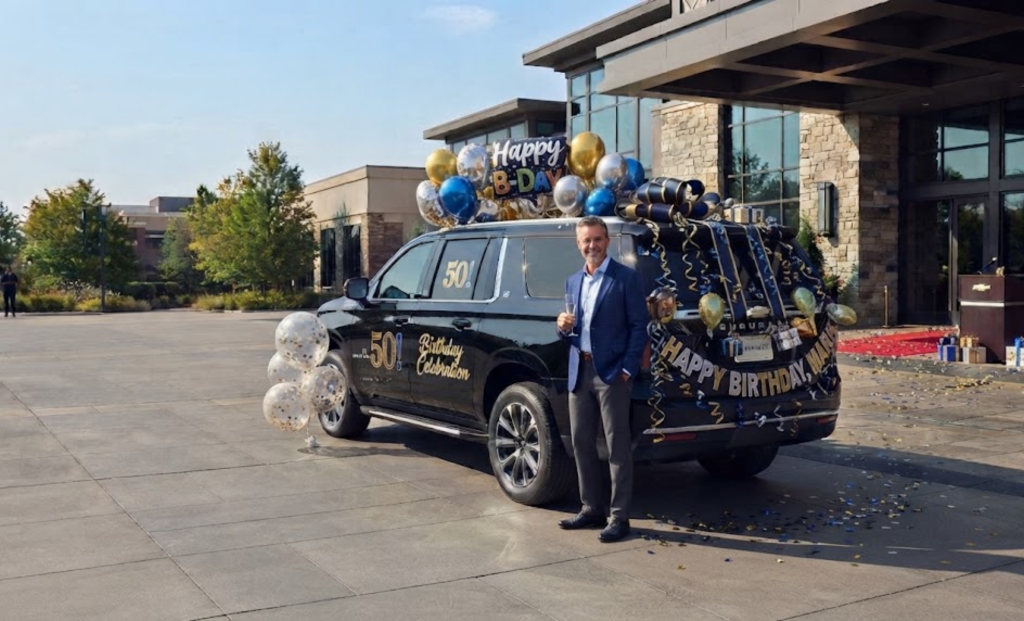 Chauffeur beside a black SUV decorated with birthday balloons