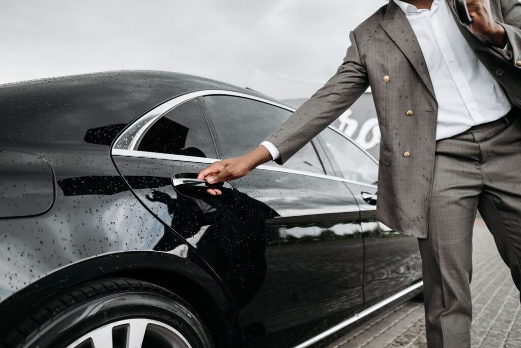Chauffeur opening a car door for a private jet passenger, Addison Airport