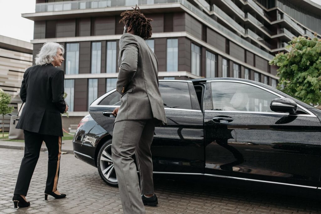 Chauffeur opening a car door for a passenger, private jet car service Dallas